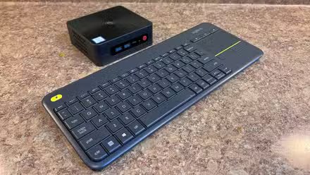 Une image d'un mini PC Beelink et d'un clavier sans fil Logitech sur un comptoir.