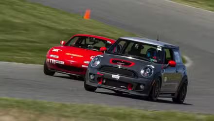 Mini Cooper et une Mazda Miata sur un circuit