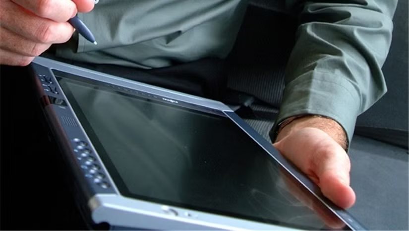 Un homme tenant une ancienne tablette Windows.