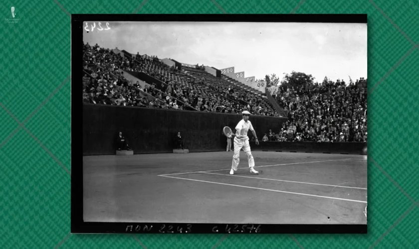 Foule de flanelles blanches de joueur de tennis des années 1920 Photo en noir et blanc d'un joueur de tennis des années 1920 portant un pantalon en flanelle blanche et une chemise à manches longues, avec une tribune pleine à craquer derrière lui