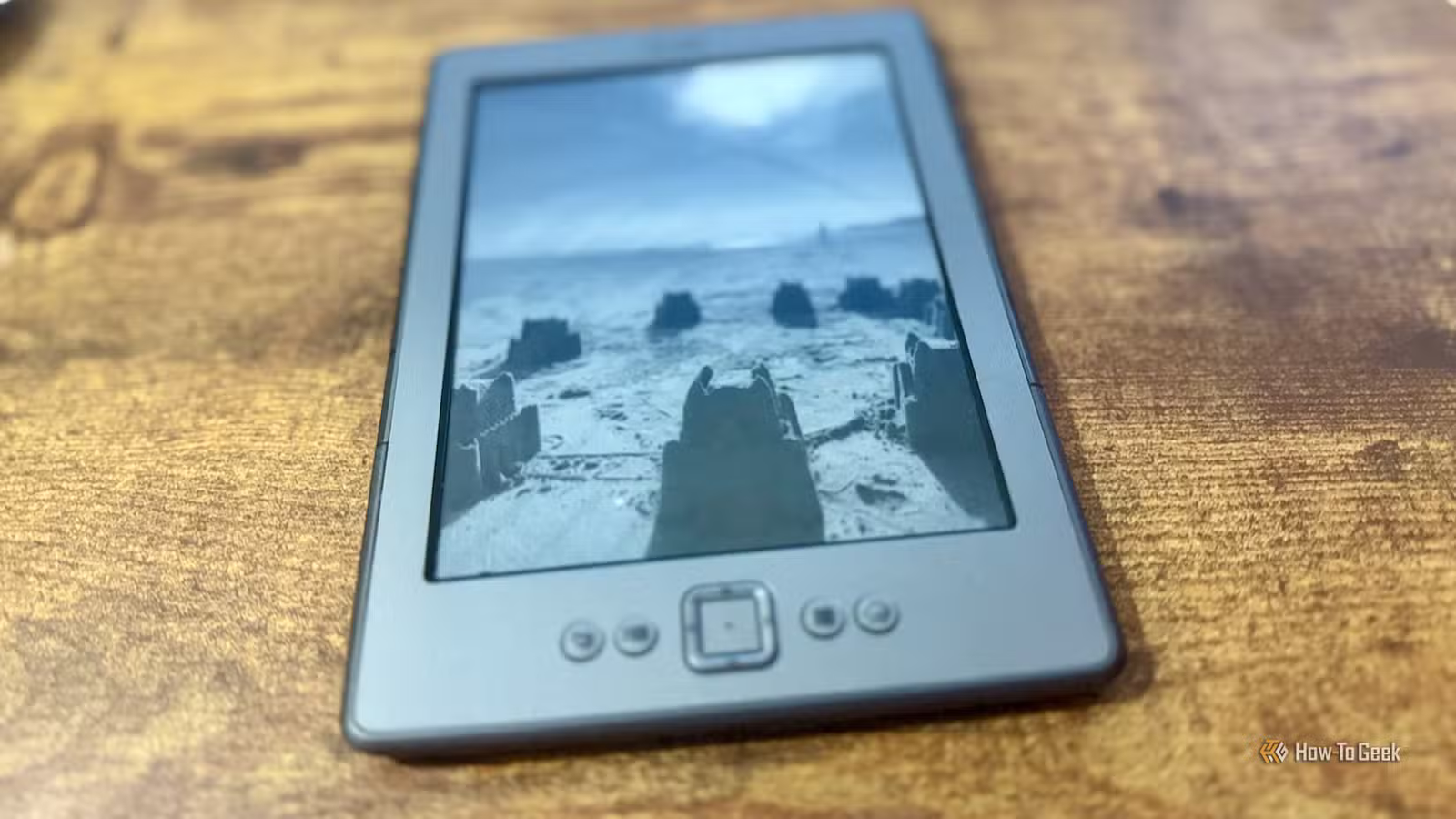 Un Kindle 4 affichant une photo de plage comme économiseur d'écran.