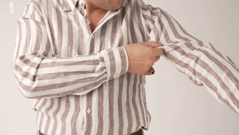 Raphael porte une chemise en lin rayé blanc et marron de Spier & Mackay.