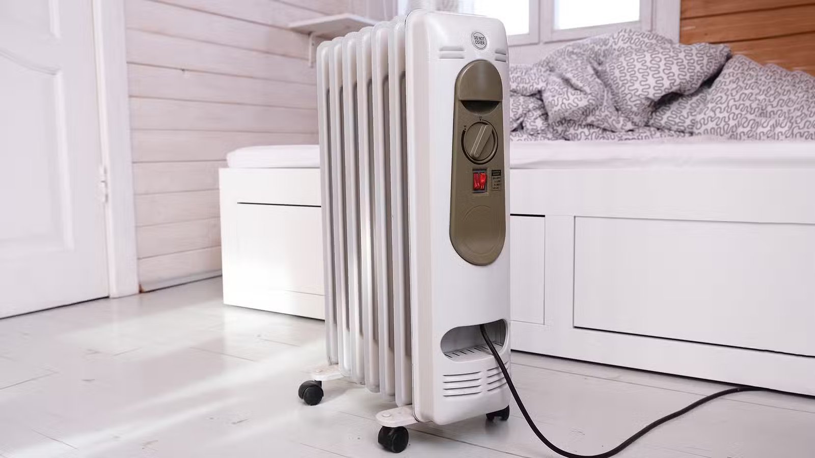 Un radiateur à huile posé à côté d’un banc intérieur.