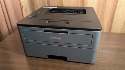 Une imprimante laser Brother noir et gris. 