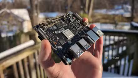 Main d'une personne tenant l'ordinateur monocarte VisionFive2 RISC-V à l'extérieur.