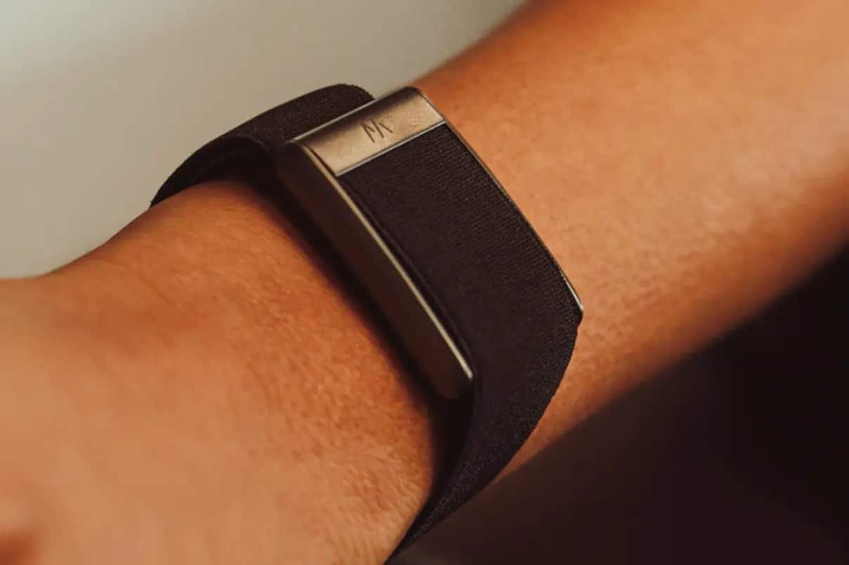 Tracker d'activité WHOOP 5.0 porté au poignet avec un bracelet noir