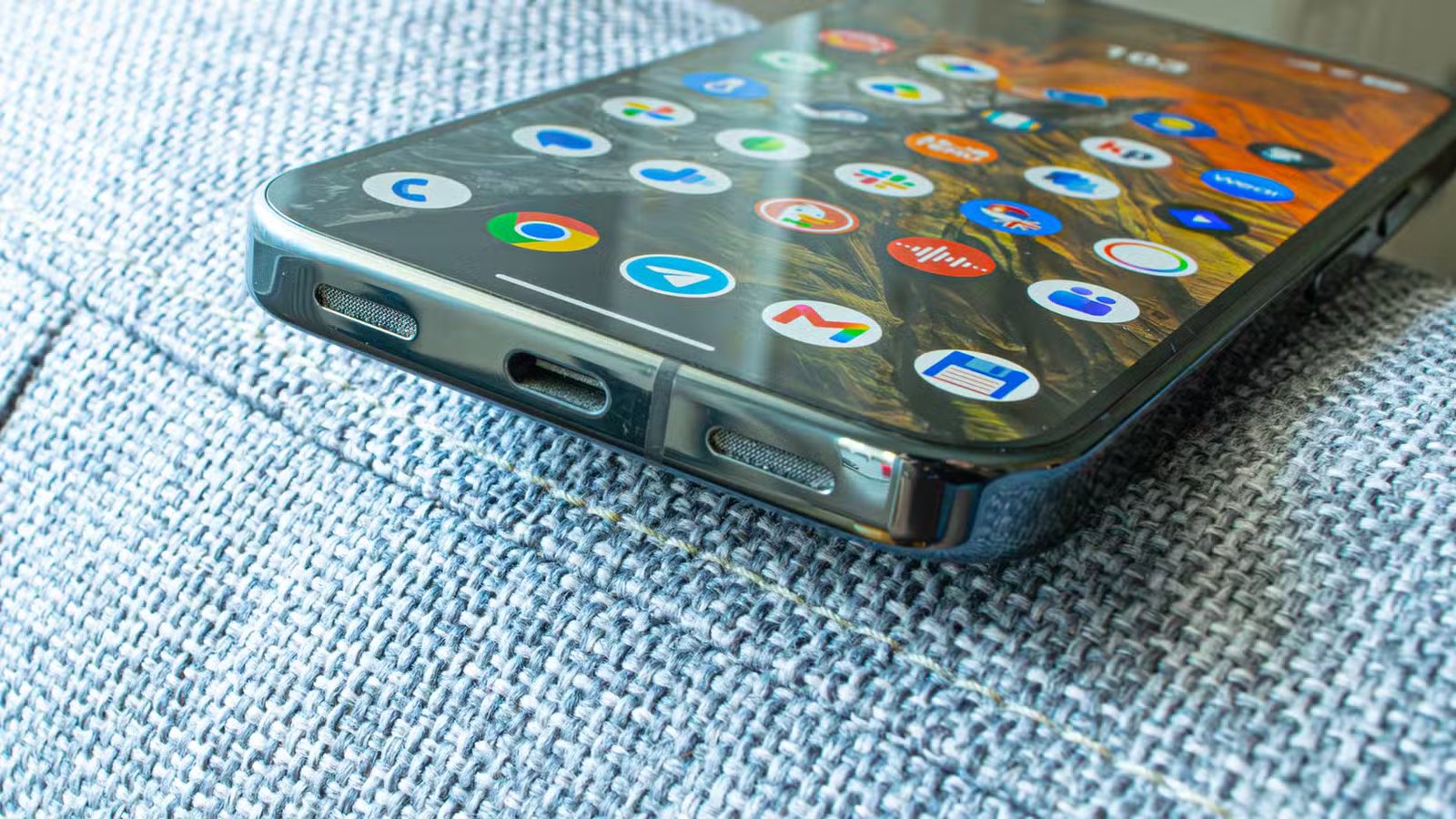 Un Pixel 10 Pro posé sur un canapé avec son port USB au point.