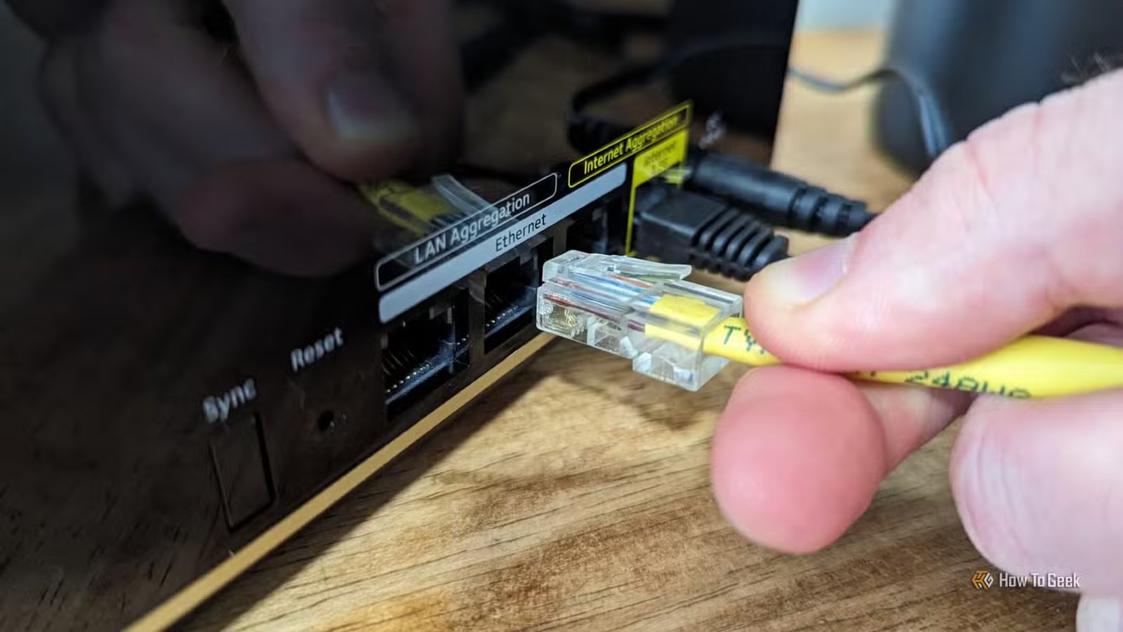 Personne connectant un câble Ethernet au routeur principal Netgear Nighthawk MK93S.