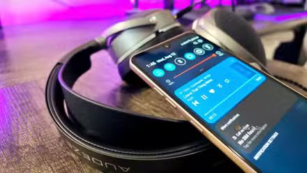 Un smartphone LG V60 ThinQ posé sur le casque Audeze LCD-S20, montrant le 