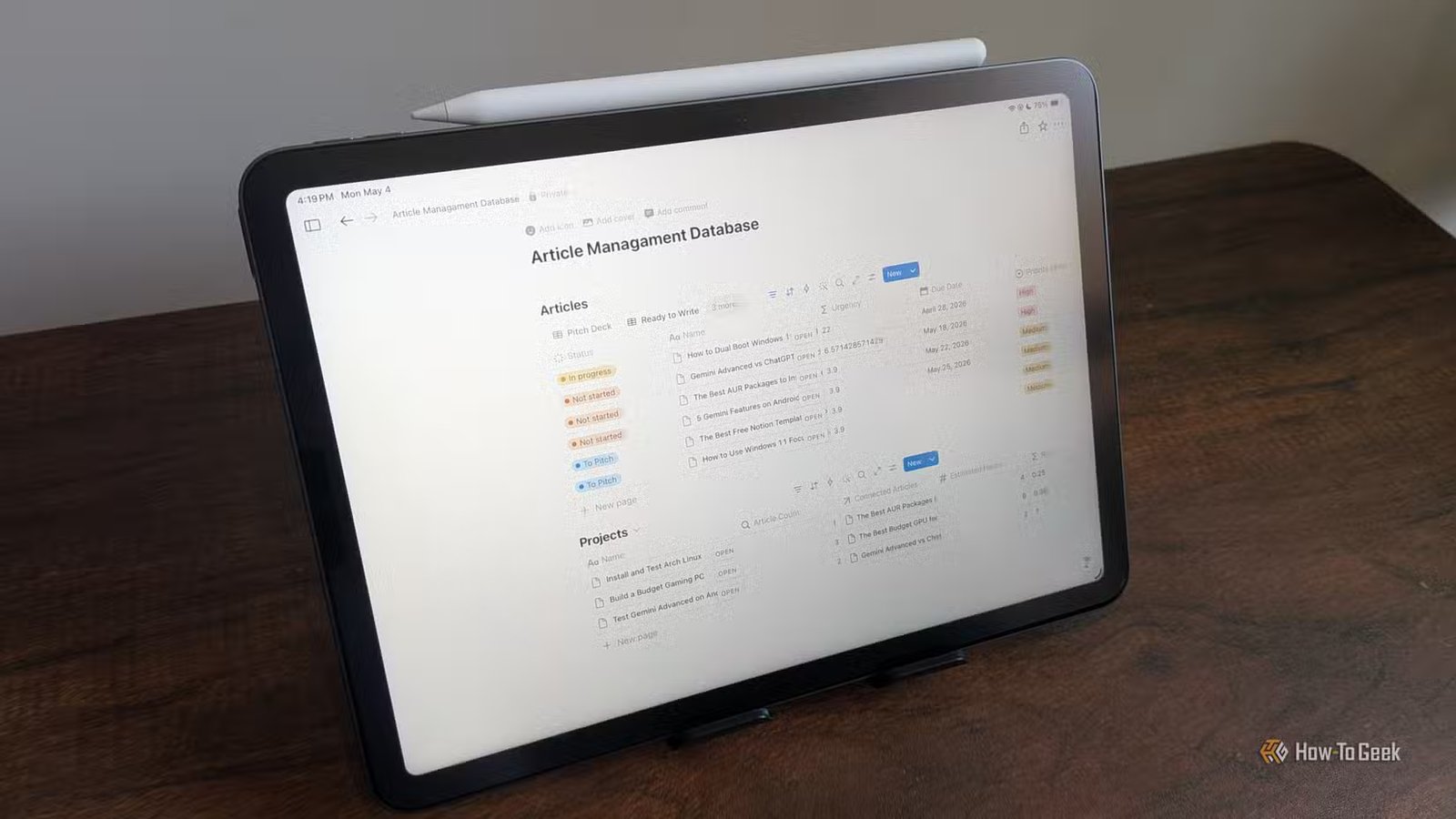 Base de données de gestion d'articles ouverte dans Notion sur un iPad Air avec Apple Pencil posé sur le dessus.-1