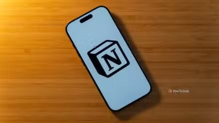 Un iPhone 17 Pro avec le logo Notion sur fond blanc posé sur un bureau en bambou.