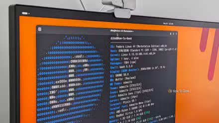 Un moniteur PC avec un terminal Linux ouvert affichant la sortie FastFetch pour Fedora.