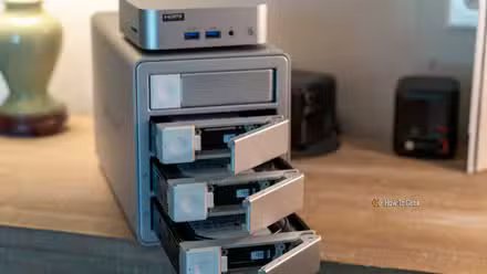 Mini PC GEEKOM A5 sur DAS ORICO MacData 4 baies avec plateaux de disques ouverts.