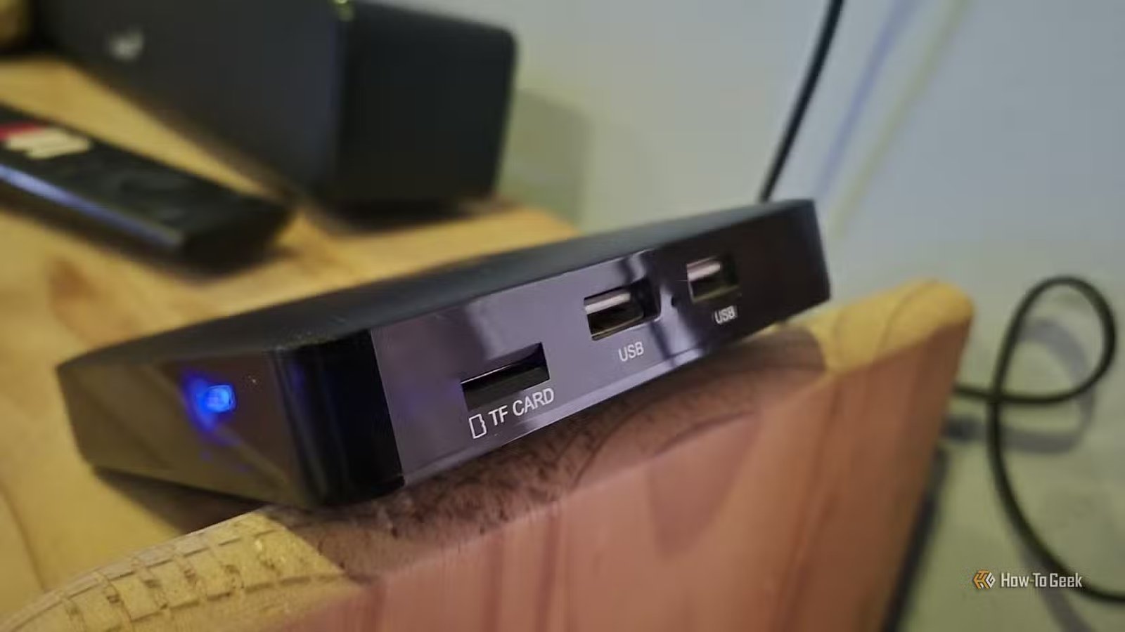 Un boîtier TV Android Ematic dv8235 en équilibre sur le bord d'une étagère 