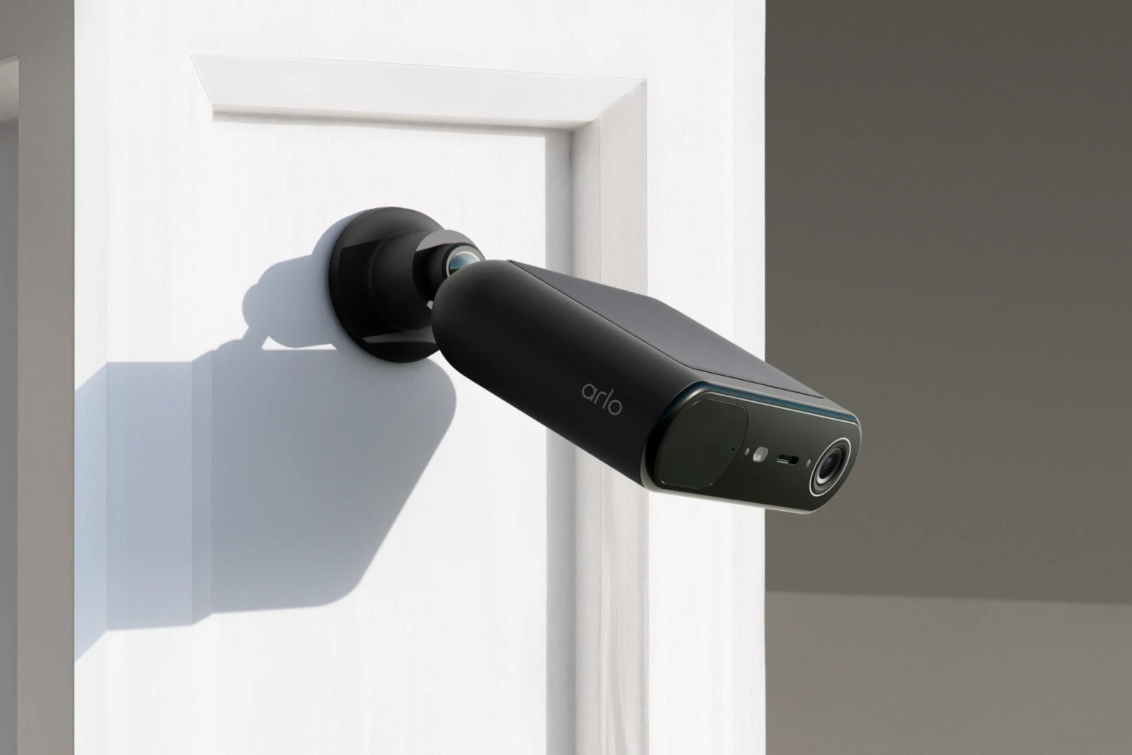 La caméra Arlo Essential Solar en noir, fixée sur une colonne.