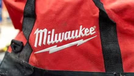 Le logo Milwaukee brodé en blanc sur une trousse à outils rouge.