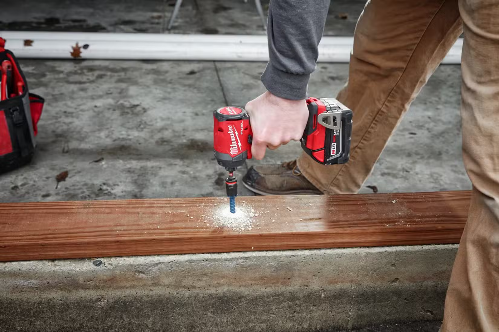 Milwaukee M18 CARBURANT 1/4" visseuse à percussion 2953-20 enfonçant une vis à travers le bois dans le béton