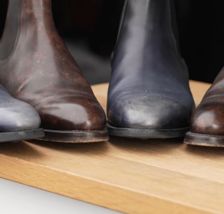 Vidéo d'examen des bottines Chelsea, point culminant 5 Une rangée d'orteils de bottes Chelsea côte à côte sur une surface en chêne