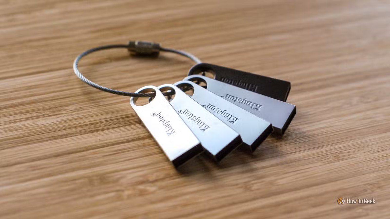 Un porte-clés avec cinq clés USB Kingston sur une surface en bois.