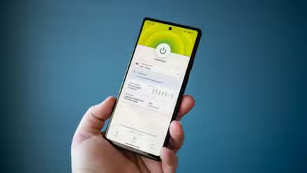 Homme tenant un téléphone avec une application VPN affichant le statut « Connecté ».