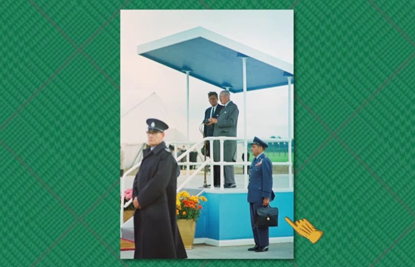 Support de révision pour porte-documents Jfk Le président Kennedy se tient sous un auvent lors d'une cérémonie en plein air tandis qu'un officier de l'armée de l'air en uniforme attend en dessous, tenant une mallette noire.