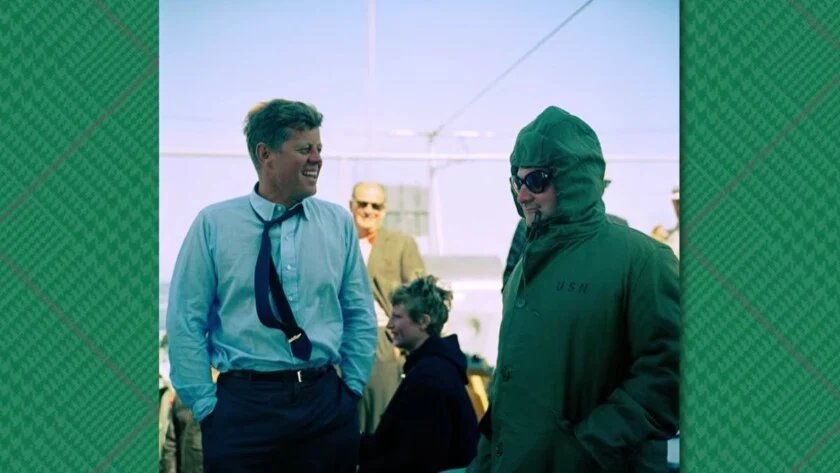 Pince À Cravate Jfk Candid Usn Le président Kennedy rit dans une chemise à col ouvert et une cravate à côté d'un homme vêtu d'une parka à capuche de l'US Navy.