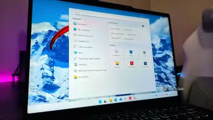 Image d'un ordinateur portable Lenovo affichant une barre des tâches simplifiée et un menu de recherche Windows.