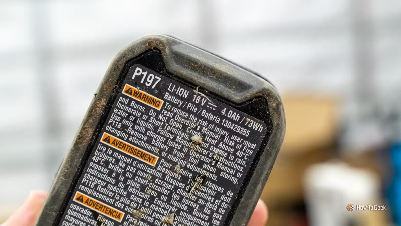 Gros plan sur l'étiquette d'avertissement multilingue de la batterie Ryobi P197 18 V 4,0 Ah.