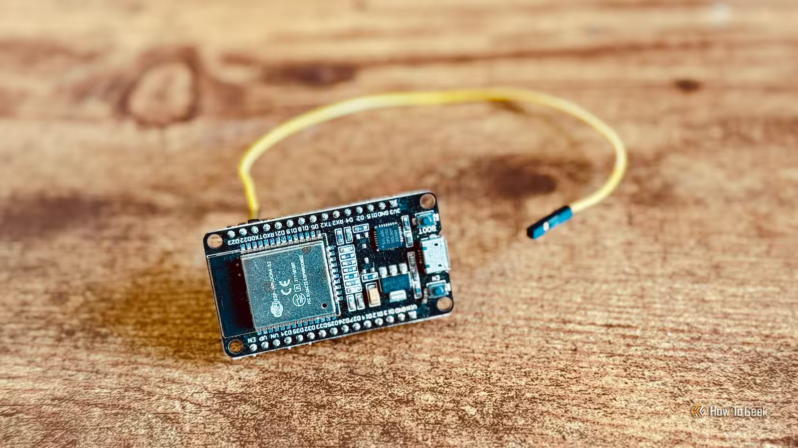 Un ESP32 posé sur un bureau, avec un câble connecté à l'une des broches GPIO.