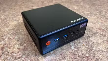 Une image d'un mini PC Peladn W04 posé sur un comptoir.